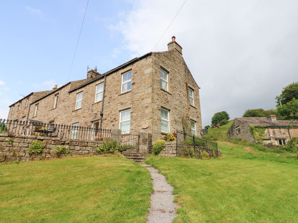 A stone house with a fence and pathway at South View, Gunnerside near Reeth