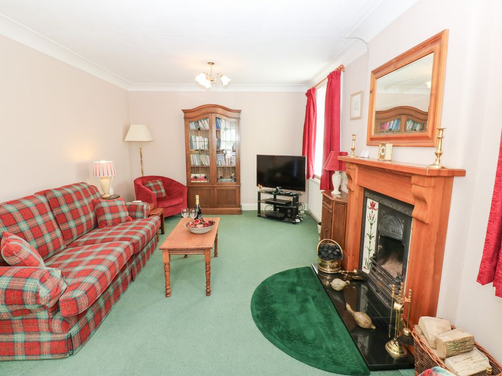 A living room with a sofa and fireplace at South View, Gunnerside near Reeth