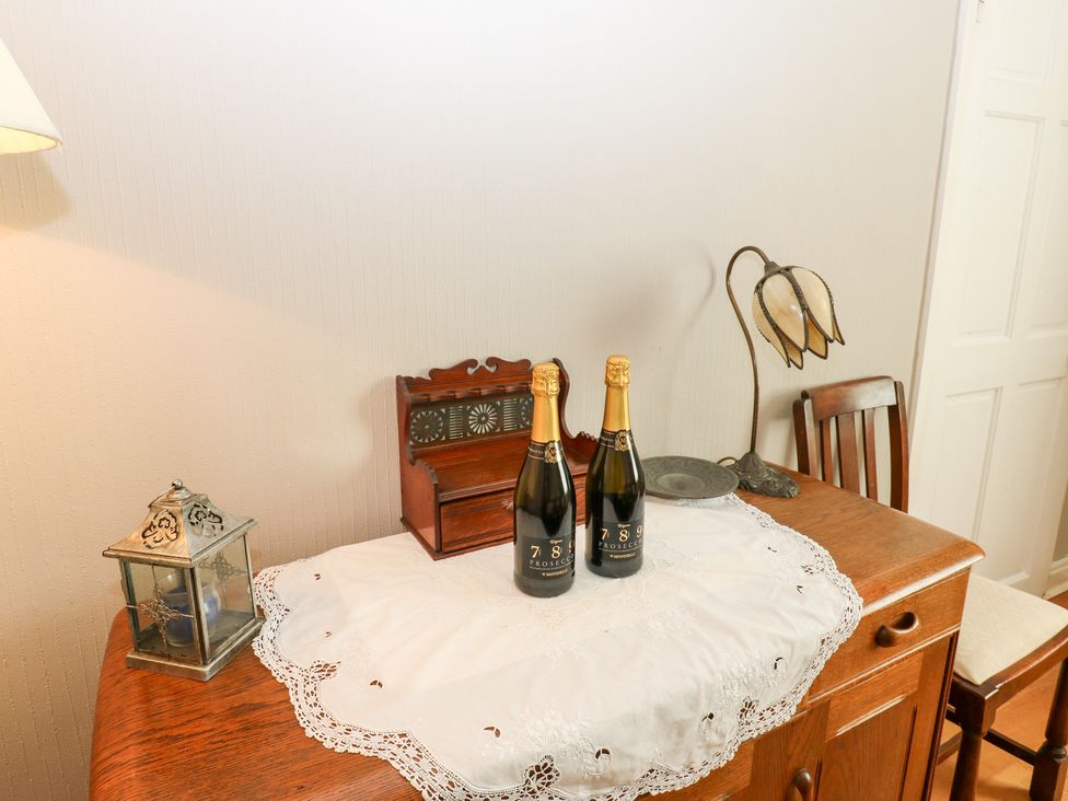 A table with bottles of prosecco and decorative items at South View, Gunnerside