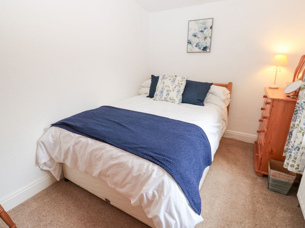 A bedroom with a bed and furniture at South View, Gunnerside near Reeth