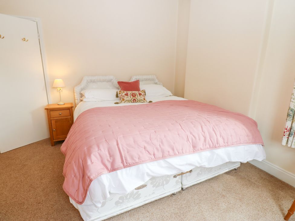 A bedroom with a bed and bedside table at South View, Gunnerside