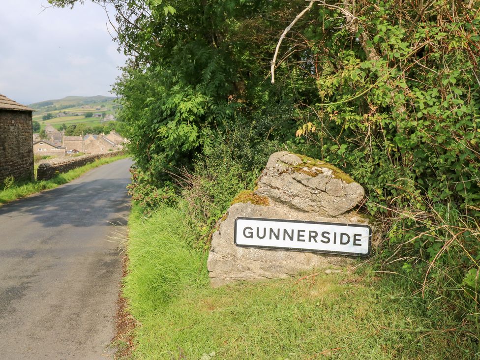 A road sign for Gunnerside located near a grassy area