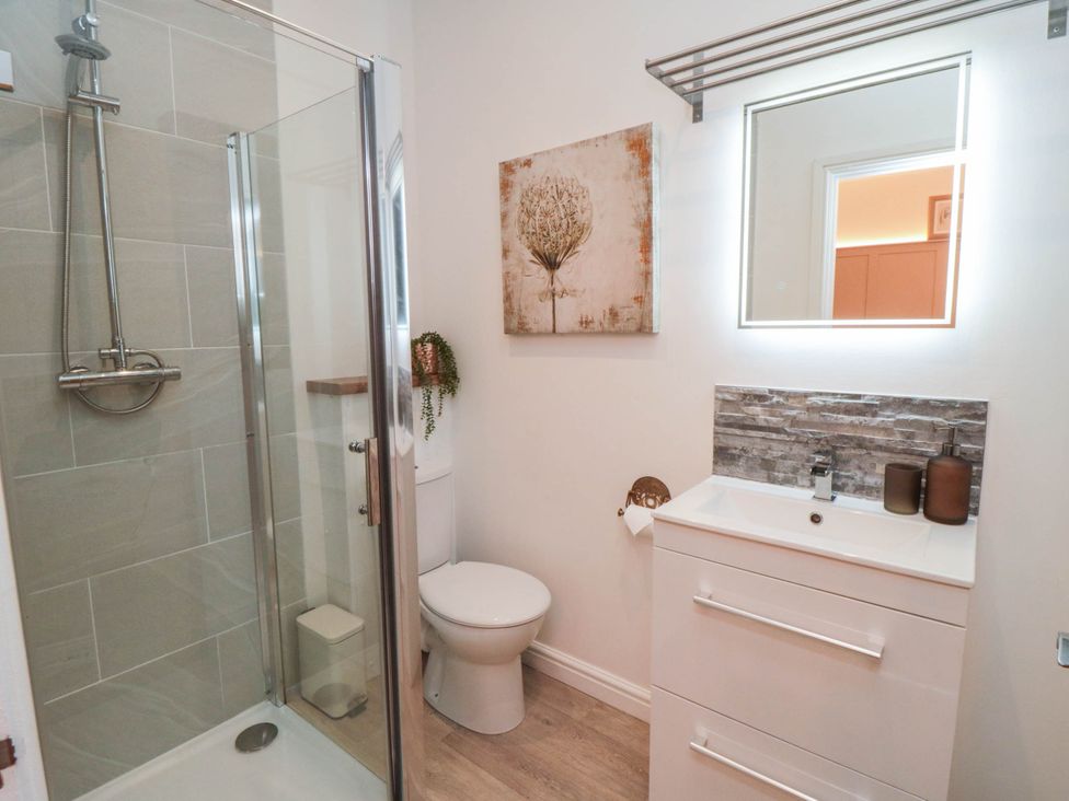 A bathroom with a shower, toilet, and sink at 5 South Side