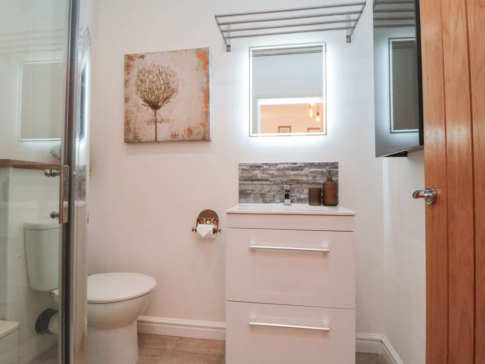 A bathroom with a sink, mirror, and toilet at 5 South Side