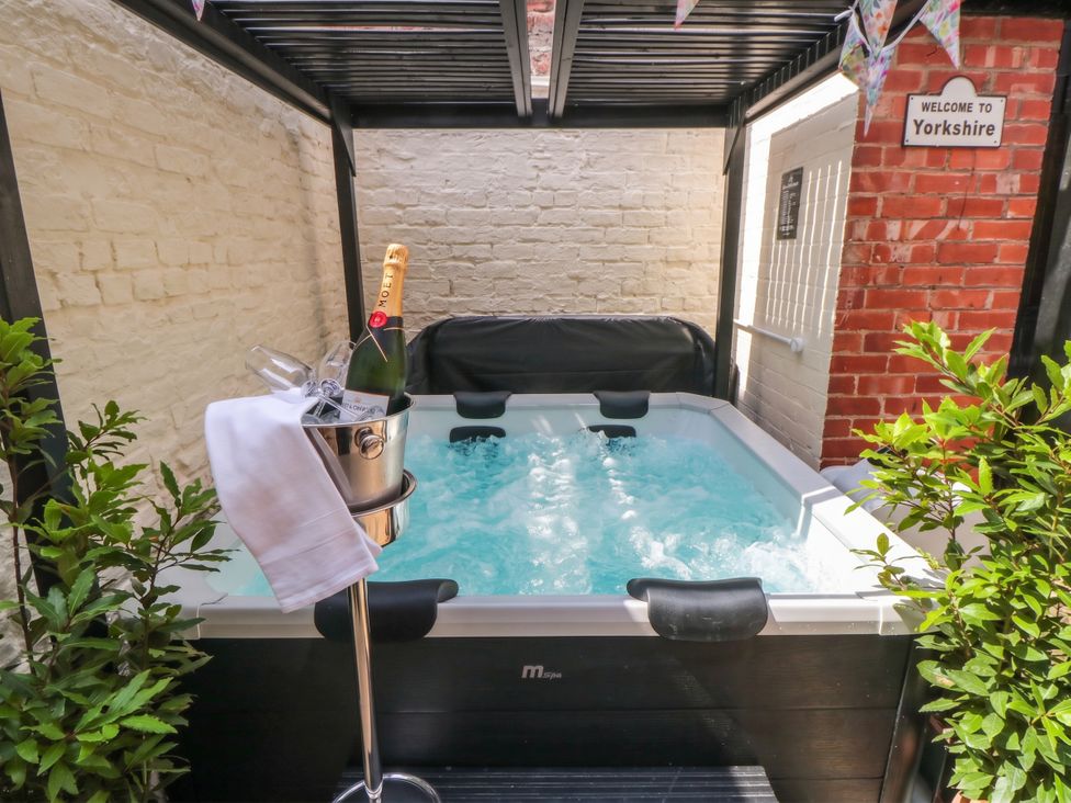An outdoor area with a hot tub and champagne at 5 South Side