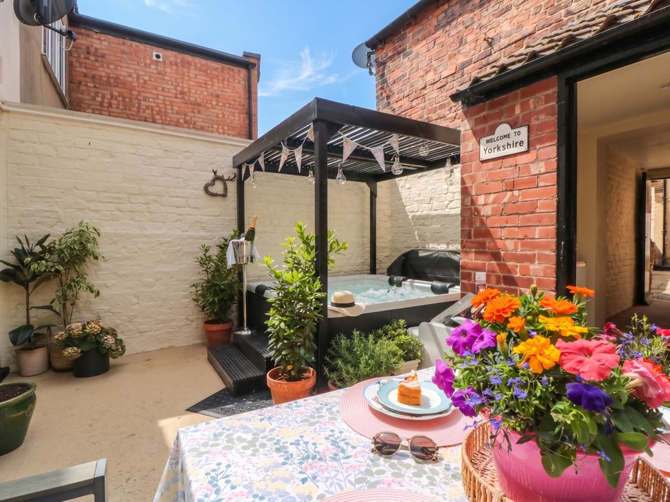 An outdoor area with a hot tub and flowers at 5 South Side