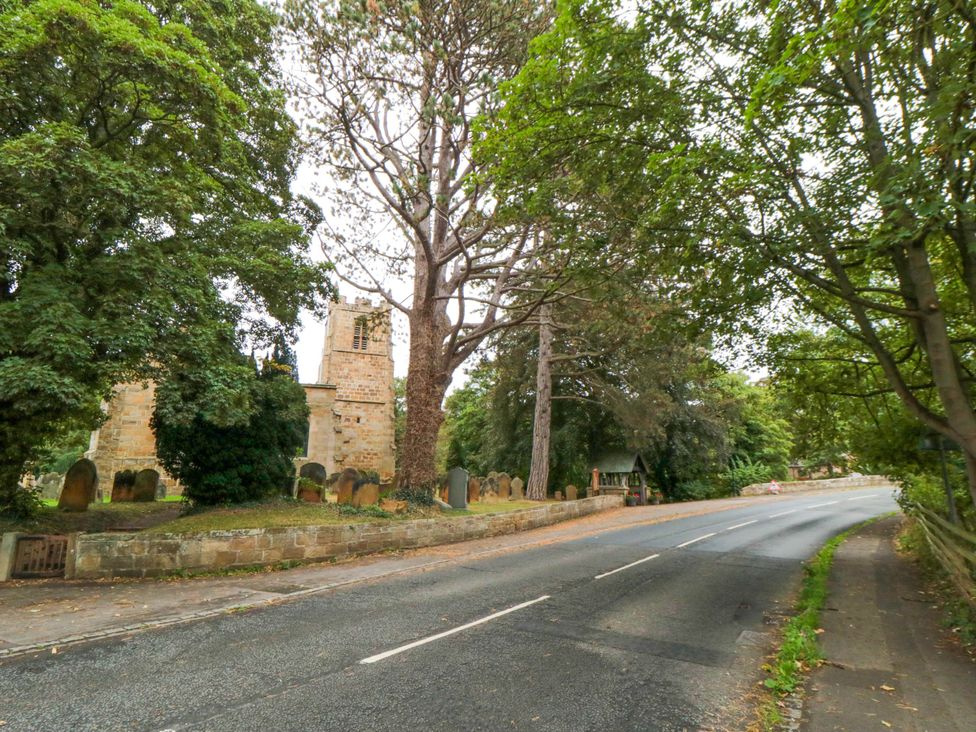An outdoor view of a church and graveyard near a road at Acorn Cottage Hutton Rudby