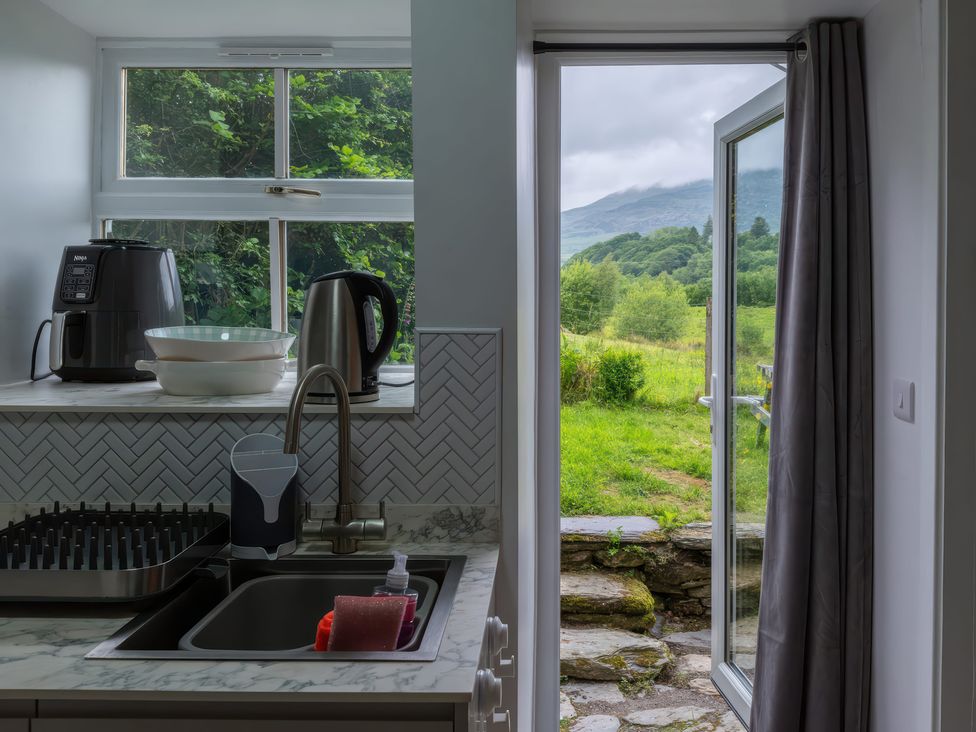A kitchen with appliances and a view of mountains at 1 Aberbeinw Dolwyddelan