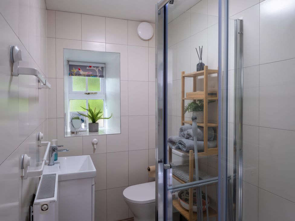 A bathroom with a shower, toilet and sink at 1 Aberbeinw in Dolwyddelan