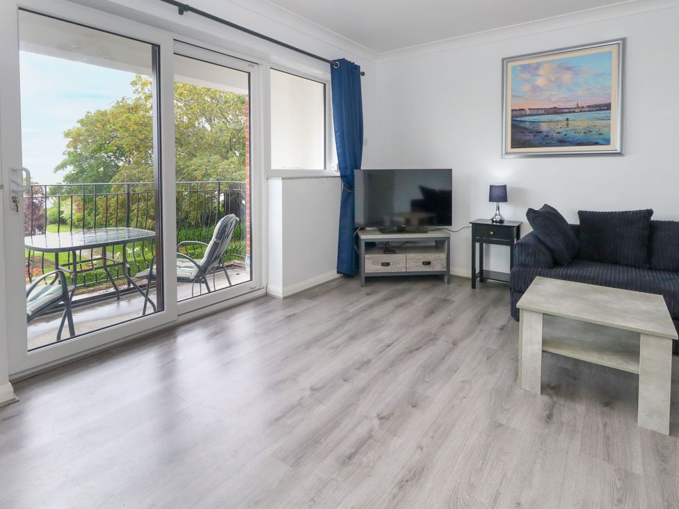 A living room with a sofa and television at The View in Weymouth
