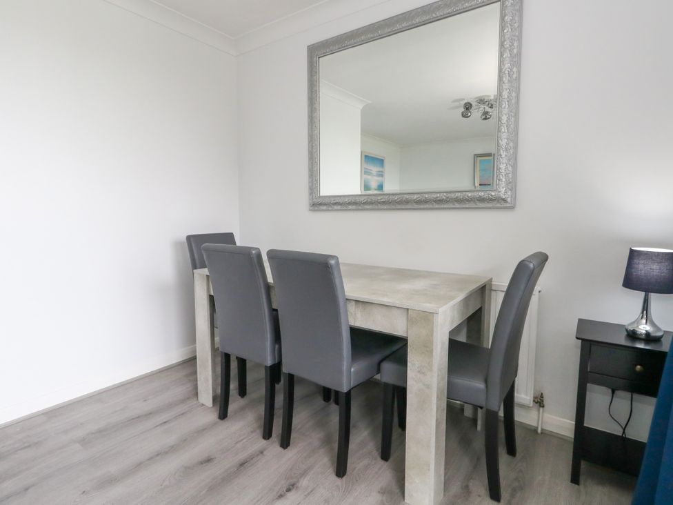 A dining room with a table and four chairs at The View in Weymouth