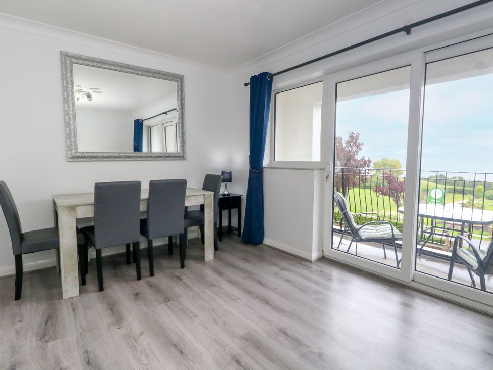 A dining room with a table and chairs at The View in Weymouth