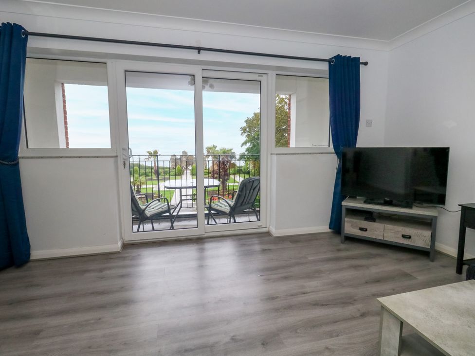 A living room with a sliding door leading to a patio at The View in Weymouth