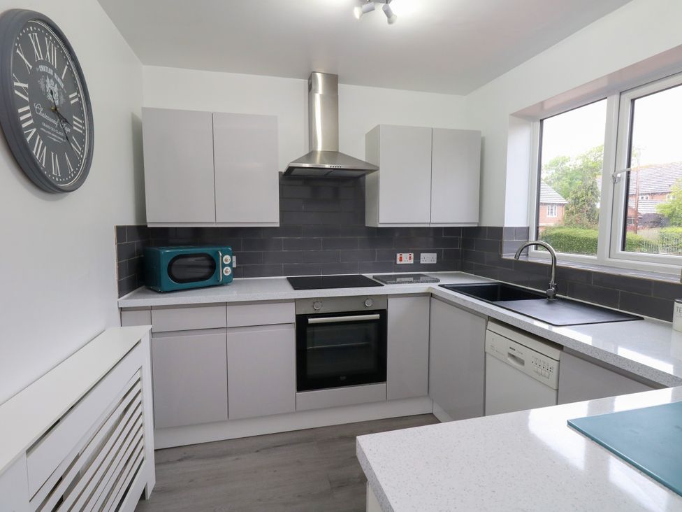 A kitchen with cabinets, sink, oven, microwave, and dishwasher at The View in Weymouth