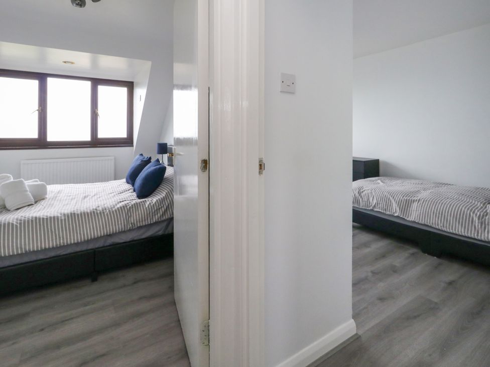 A bedroom with two beds and windows at The View in Weymouth