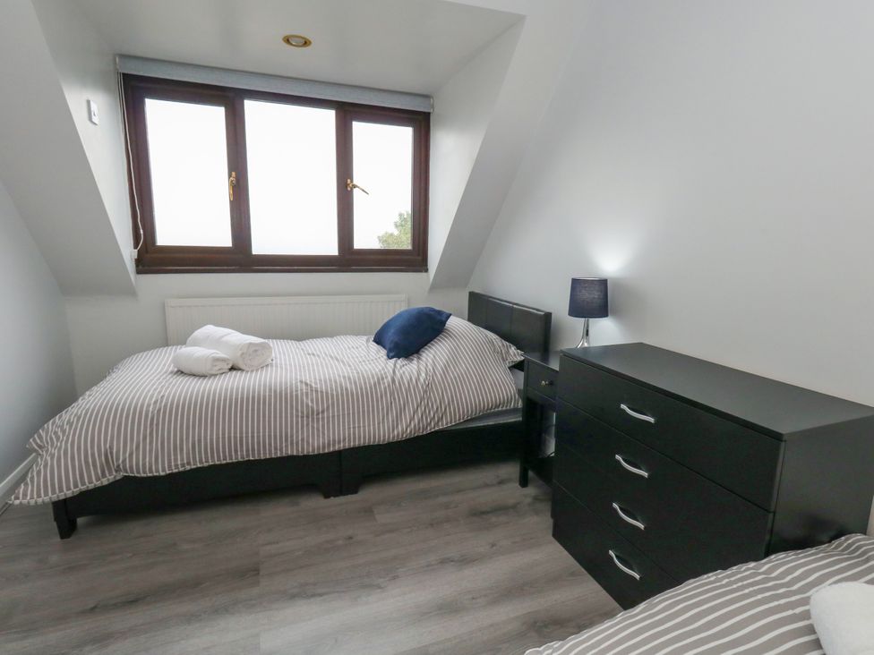 A bedroom with two single beds and a dresser at The View in Weymouth