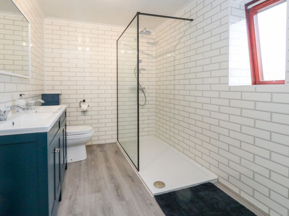 A bathroom with a shower, toilet, and sink at The View in Weymouth