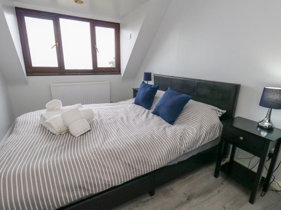 A bedroom with a bed and window at The View in Weymouth