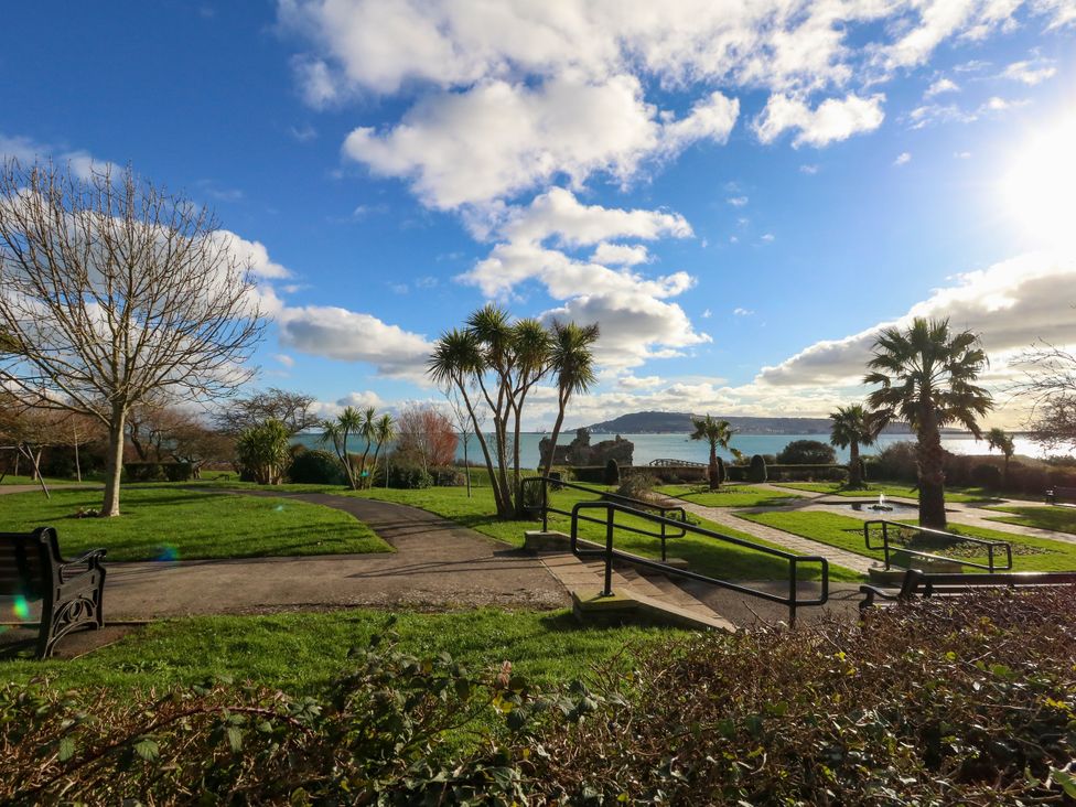 A park with palm trees and a view of the sea at The View in Weymouth