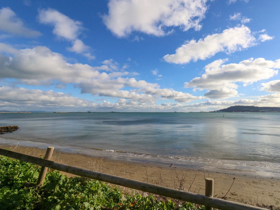 A beach with water and clouds at The View in Weymouth