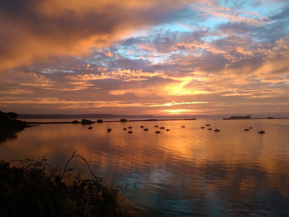 A sunset over water with boats docked at The View in Weymouth