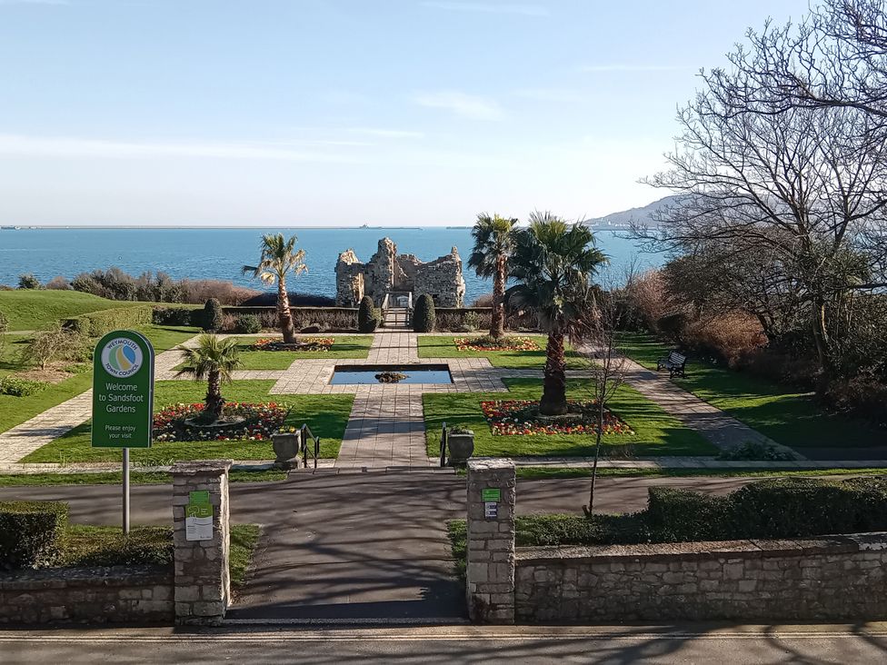 A garden with palm trees and a view of the sea at The View in Weymouth