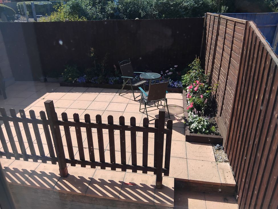 A garden with a table and chairs on paving stones at The View in Weymouth