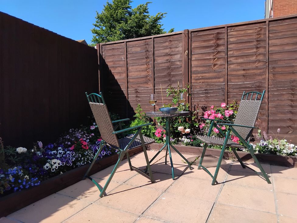 A garden with two chairs and a table at The View in Weymouth