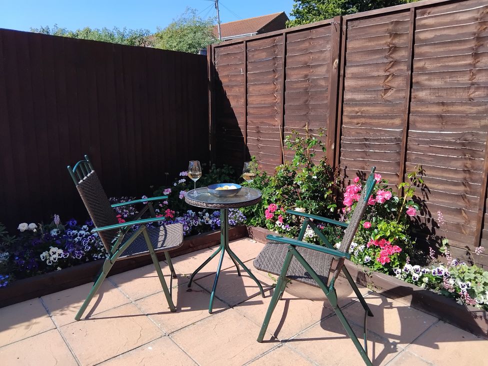 A garden with two chairs and a table at The View in Weymouth