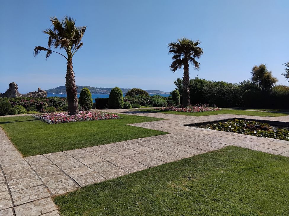 A garden with palm trees and flowers at The View in Weymouth
