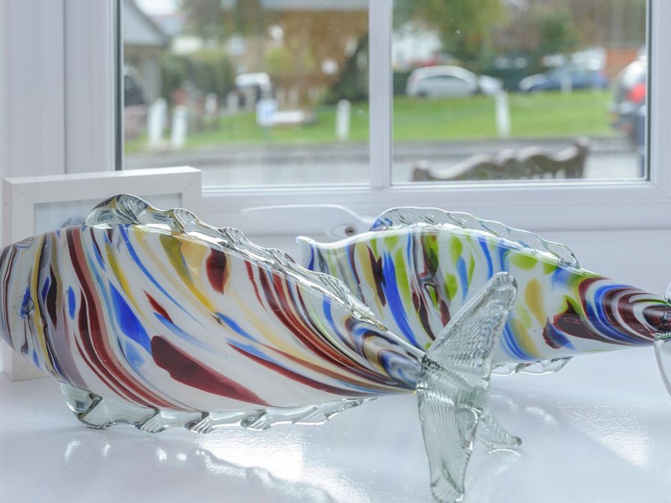 Glass fish sculptures and a picture frame on a windowsill at The Forge in Morpeth