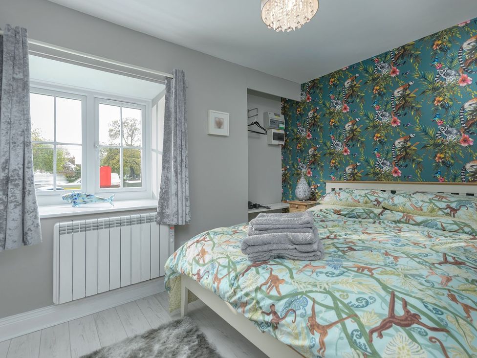 A bedroom with a bed and patterned wallpaper at The Forge in Morpeth