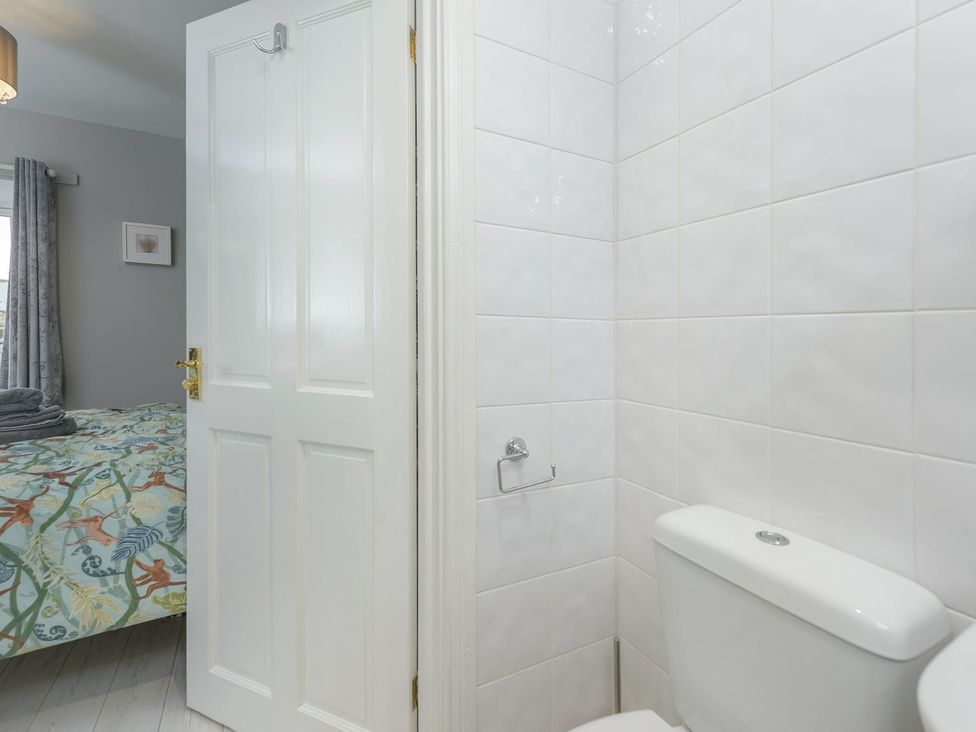 A bathroom with a toilet and a door leading to another room at The Forge in Morpeth