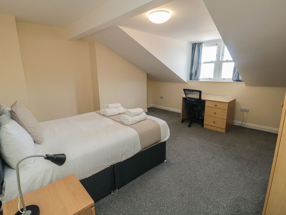 A bedroom with a bed and desk at The Newborough Apartment 5 Scarborough