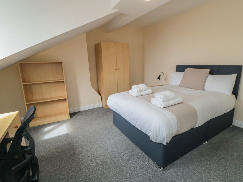 A bedroom with a bed and a desk at The Newborough Apartment 5 Scarborough