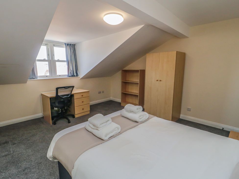 A bedroom with a bed and desk at The Newborough Apartment 5 Scarborough