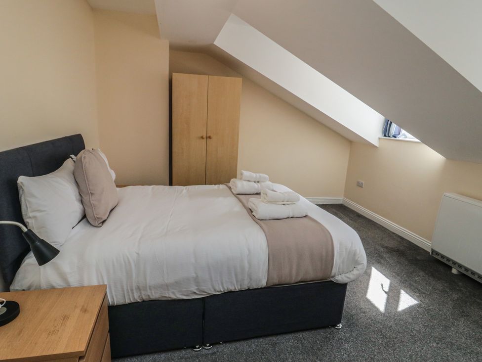 A bedroom with a bed and wardrobe at The Newborough Apartment 5 Scarborough