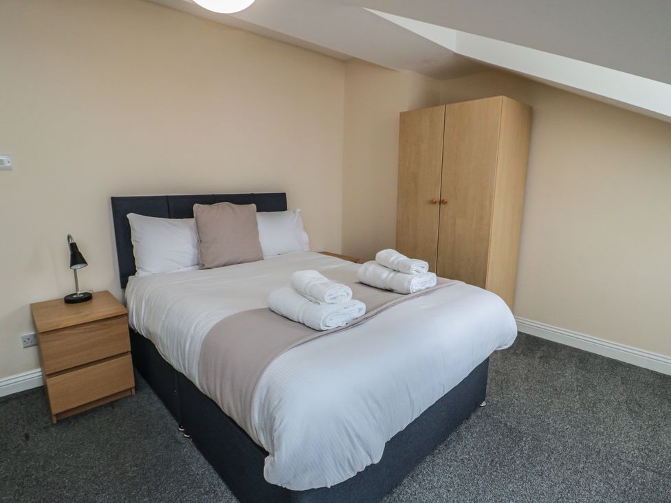 A bedroom with a bed and nightstand at The Newborough Apartment 5 Scarborough