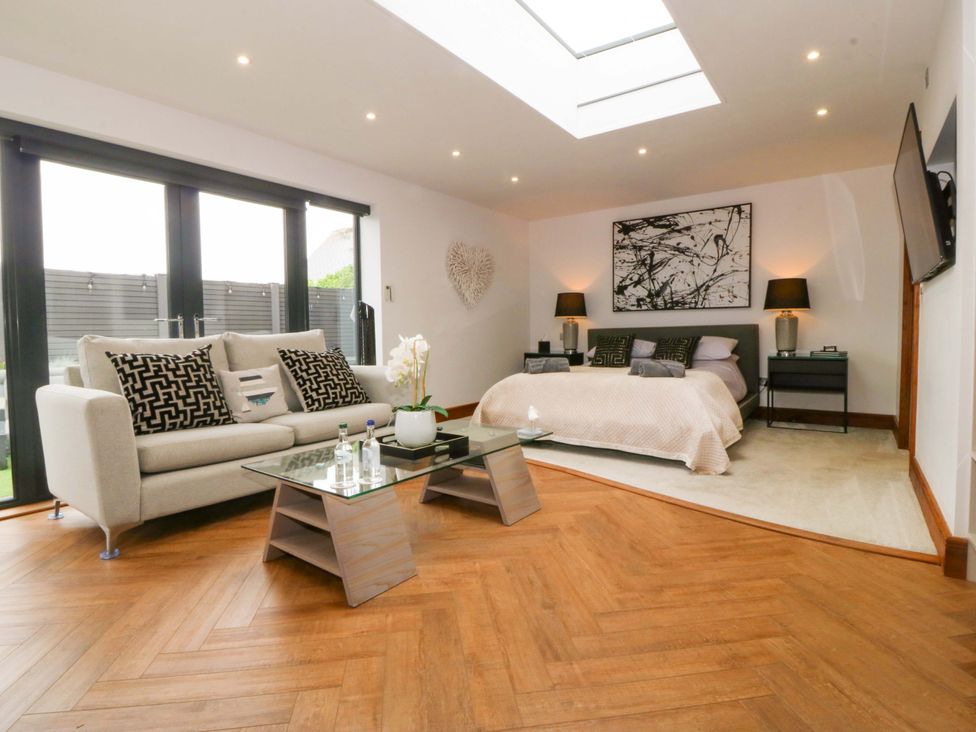 A bedroom with a bed and sofa at Lodge in Llangefni