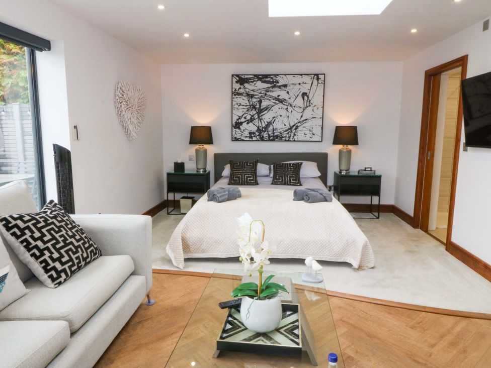 A bedroom with bed, sofa and coffee table at Lodge in Llangefni
