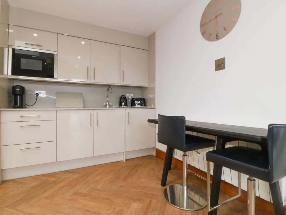 A kitchen with cabinets and appliances at Lodge in Llangefni