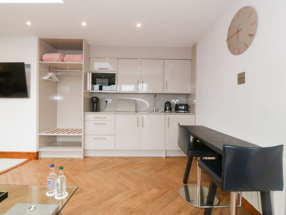 A kitchen with appliances and a table at Lodge in Llangefni
