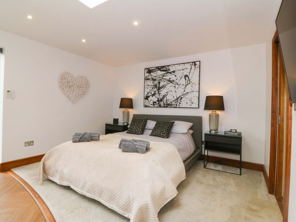 A bedroom with a bed and bedside tables at Lodge in Llangefni