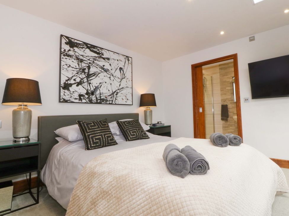 A bedroom with a bed and bedside tables at Lodge in Llangefni
