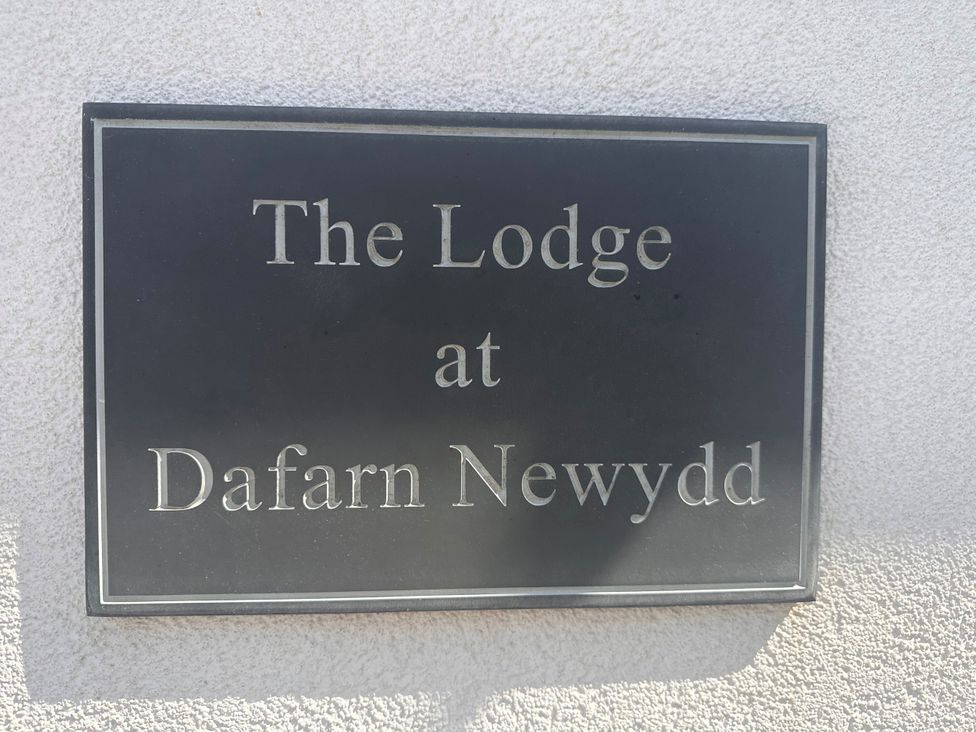 A sign that says The Lodge at Dafarn Newydd