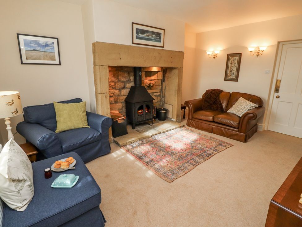 A living room with a fireplace and seating area at Peary House in Alnwick