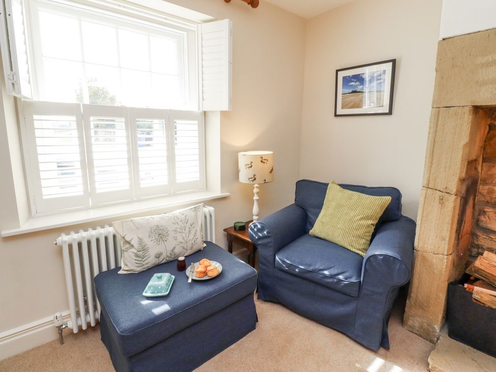 A snug with an armchair and side table at Peary House in Alnwick