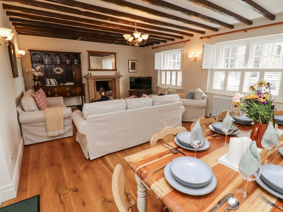A living room with a sofa and dining table at Peary House in Alnwick