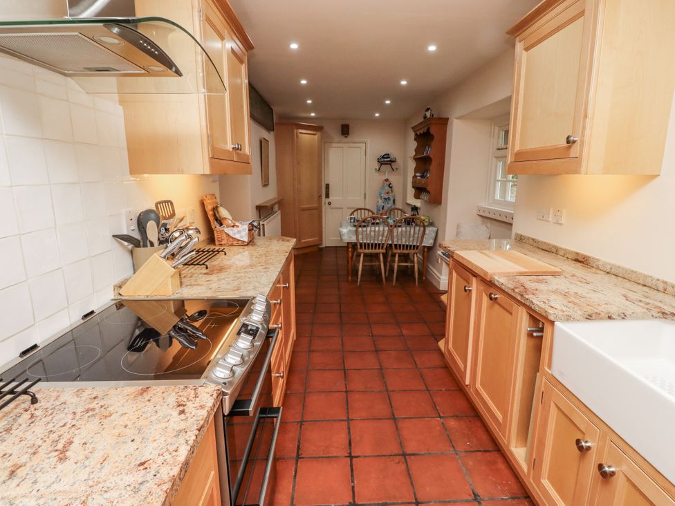 A kitchen with cabinets and dining area at Peary House in Alnwick