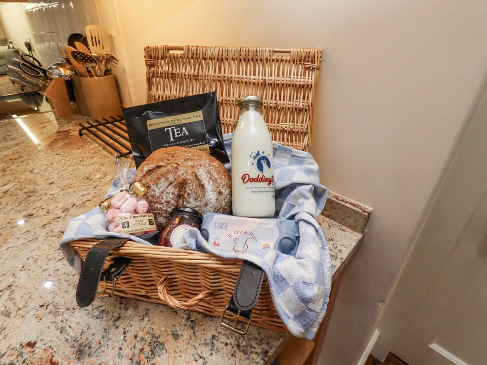 A basket containing tea, bread, milk, and candy at Peary House in Alnwick